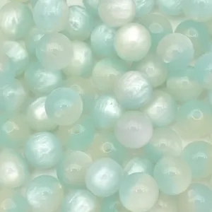 Close-up detail of light blue pearlescent resin cat-eye beads for DIY jewelry making.