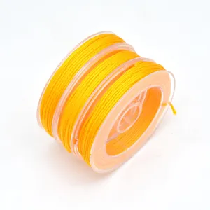 Detailed view of bright yellow nylon cord on spool, perfect for DIY jewelry making and crafting.