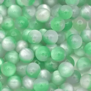 Close-up detail of green and white resin cat eye beads for DIY handmade jewelry making.