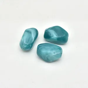 Close-up detail of irregular cyan swirled acrylic beads, smooth finish, ideal for jewelry.