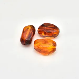 Close-up of irregular stained acrylic amber imitation beads with drilling holes for DIY jewelry.