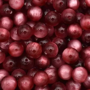 Close up detail of red resin cat eye beads, perfect for DIY jewelry making and crafts.