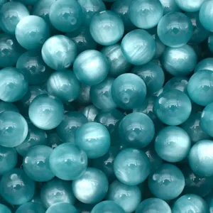 Close-up detail of blue cat eye resin beads, smooth round DIY craft supplies for bracelets.