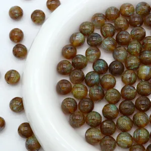 Detail shot of sparkling brown resin beads with starry glitter effect for DIY jewelry making.