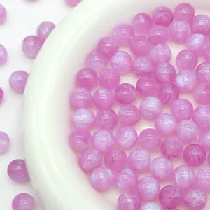 Close-up detail of glossy pink starry resin beads for DIY jewelry making and crafting supply.