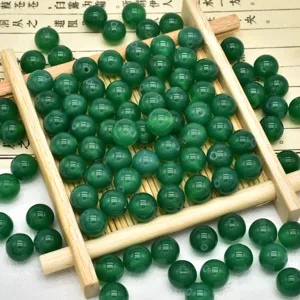 Primo piano dettagliato di perline tonde in agata verde lucida per braccialetti fai da te.