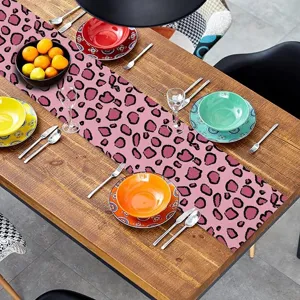 Runner da tavola leopardato rosa in ambientazione, tessuto decorativo per cucina e sala.