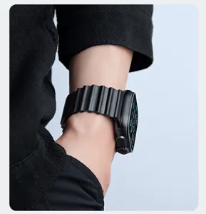 Gros plan d'un bracelet de montre noir ondulé porté au poignet, texture détaillée.
