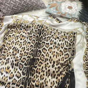 Seidentuch mit Leopardenmuster, goldenen Ketten und Perlen, elegante Detailansicht.