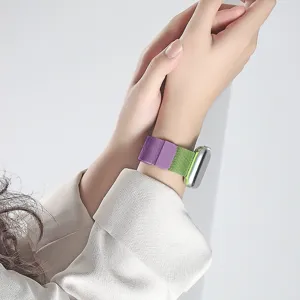 Close-up detail of the dual-color magnetic metal mesh watch strap worn on wrist.