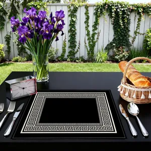 Black placemat featuring a classic Greek key geometric pattern for elegant dining table decor.