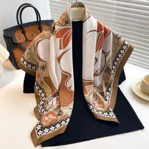 Detailed view of the elegant satin silk square scarf featuring classic orange floral patterns.