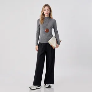 Detail shot of grey turtleneck sweater outfit styled with black wide leg pants and accessories.