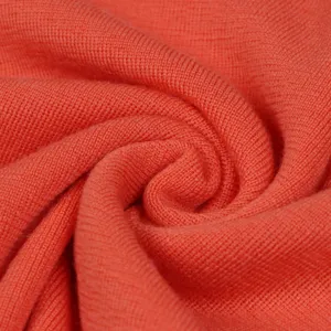 Close-up detail of soft 100% wool knitted sweater fabric texture, showing fine craftsmanship.