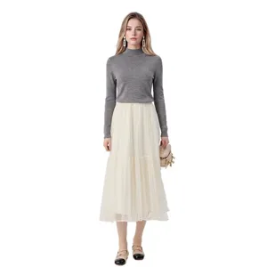 Elegant grey mock neck long sleeve knit sweater paired with a beige tulle skirt for women.