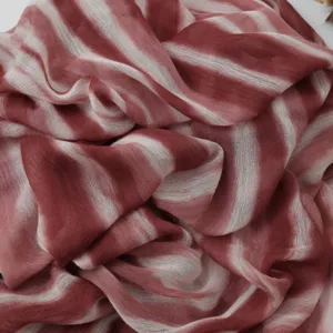 Gedetailleerde close-up van de rood-witte gestreepte gekreukte sjaaltextuur en zachte stof.