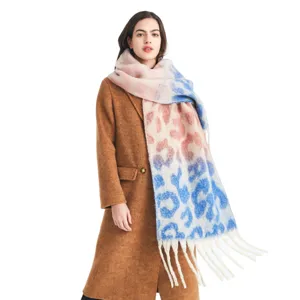 Close-up detail of the gradient pink and blue leopard print winter scarf with stylish fringes.