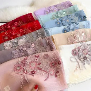 Detailed view of luxury silk embroidered scarf with delicate floral design and soft fabric.