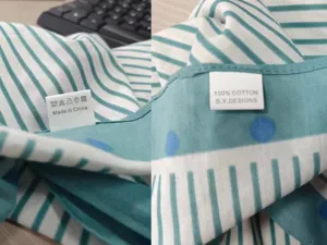 Cotton scarf detail view showing wash care label and 100% cotton material tag clearly.