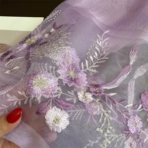 Close-up detail of luxury purple silk embroidered scarf showcasing intricate floral patterns.