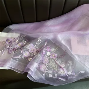 Exquisite light purple silk scarf detail featuring intricate floral embroidery and soft sheer fabric.
