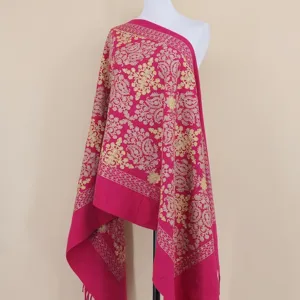 Close-up detail of luxurious pink winter cashmere scarf with exquisite gold floral embroidery design.