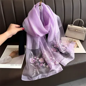 Purple silk scarf detail showing exquisite floral embroidery and soft fabric texture.