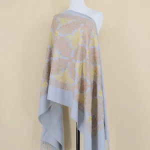 Detailed view of light blue cashmere shawl with gold floral embroidery and stylish fringe edge.