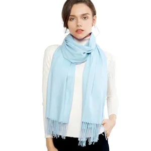 Detailed showcase of solid color fringed cashmere feel shawl scarf worn by model in studio.