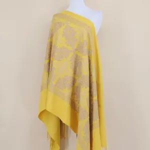 Close-up of yellow cashmere shawl with intricate gold embroidery and elegant tassel details.