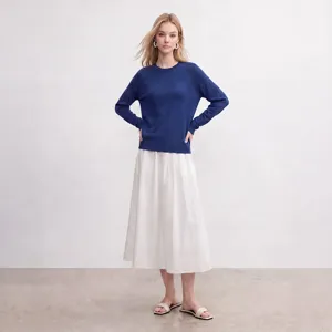 Detailaufnahme des eleganten blauen Pullovers mit Rundhalsausschnitt und weißem Rock.