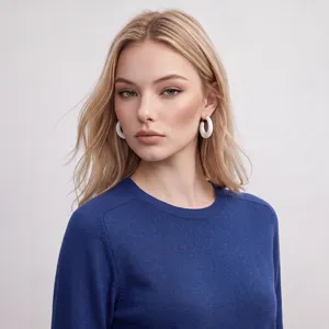 Nahaufnahme Detailansicht Damen Rundhals Strickpullover mit weißen Creolen Ohrringen.