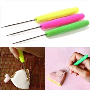 Detail view of fondant cookie royal icing scribing needles with colorful plastic handles.