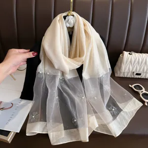 Elegant beige silk blend scarf featuring delicate pearl beaded floral designs, ideal for autumn styling.