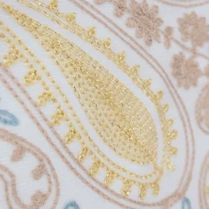 Detailopname van kasjmier-look sjaal met gouden paisley borduurwerk en zachte textuur.