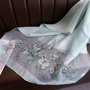 Detail view of the elegant silk embroidered scarf, showing exquisite floral craftsmanship.