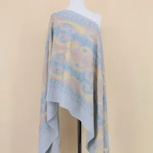 Detailopname van de grijsblauwe kasjmier sjaal, voorzien van elegante paisley en gouden patronen.