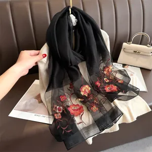 Elegant black silk embroidered scarf with vibrant floral patterns, chic women accessory.