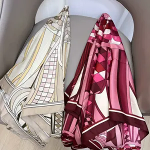 Close-up view of geometric printed twill silk scarves draped on a modern gray chair gracefully.