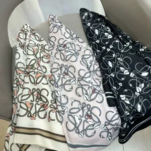 Detail view of printed silk twill scarf with monogram pattern, elegant neckerchief.