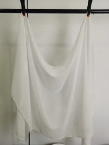 Detailed view of a white chiffon scarf, lightweight and breathable fabric for women.
