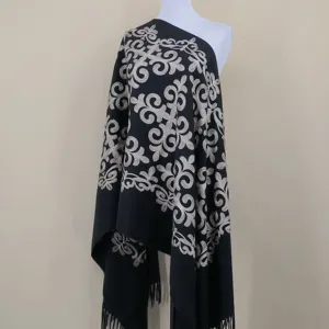 Close-up detail view of the embroidered ethnic pattern on the black cashmere scarf.