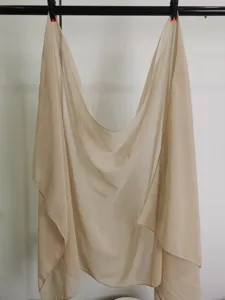 Detailed view of the lightweight beige chiffon scarf, soft texture and elegant drape.