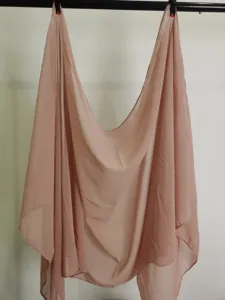Close up view of solid color chiffon shawl draped elegantly on a hanging rod detail