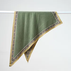 Vue détaillée d'un foulard en soie vert et doré, présentant un élégant motif de bordure.