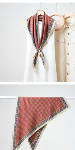 Vue de détail du foulard triangle rouge à pois cachemire, montrant le tombé et le style.