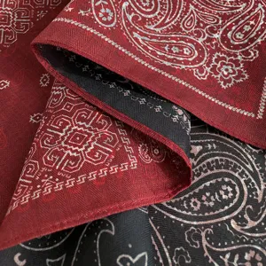 Close-up detail of vintage cotton linen paisley bandana scarf, textured red black fabric weave.