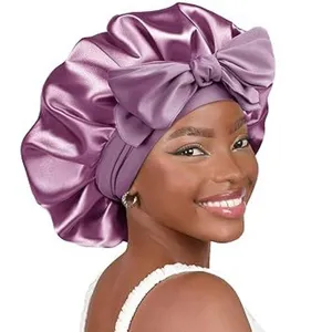 Detail view of the purple satin sleep bonnet featuring a bow and double-layer hair care design.