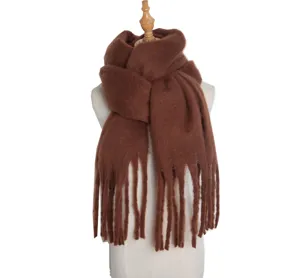 Close-up detail of soft brown knitted winter scarf with fringe, cozy texture for cold days.