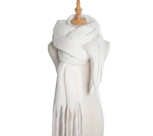 Closeup of soft white plush winter scarf detail, cozy ring yarn texture and fringe trim.